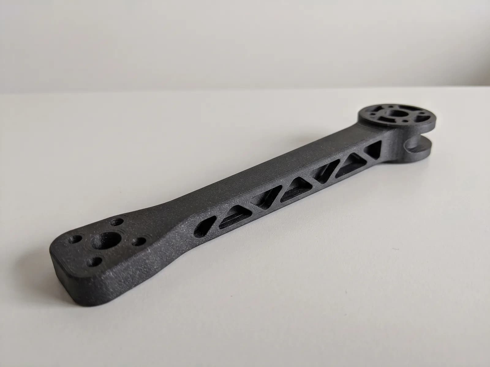 Krak drona 3D štampan u karbonu — olakšan trouglastim izrezima, sa ležištem motora