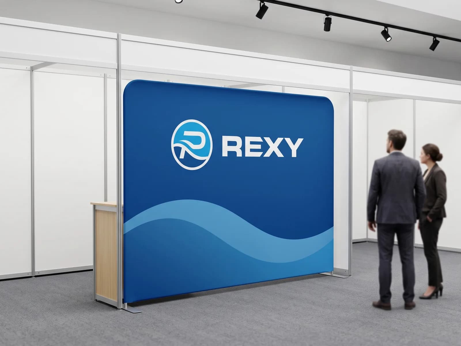 Backwall zid sa Rexy grafikom na sajmu — zategnuto platno preko aluminijumske cevne konstrukcije, sa pultom uz levu ivicu